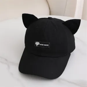 Vista detallada de la gorra negra con orejas de gato y etiqueta delantera hecha a mano.