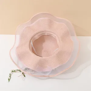 Detailansicht des rosa gewebten Strohhutes mit zarter breiter Netz-Wellenkrempe im Detail.