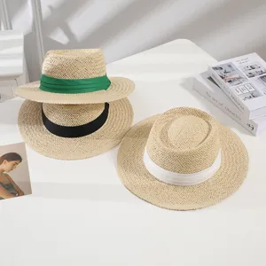 Detail view of summer straw hat with wide brim and ribbon, perfect for beach and casual wear.