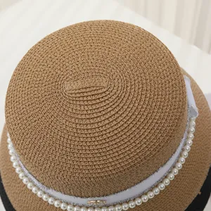 Detail shot of the women's vintage straw cloche hat featuring elegant pearl and ribbon trim.