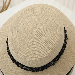 Gros plan sur le chapeau de paille plat d'été avec une bordure en dentelle noire, détail.