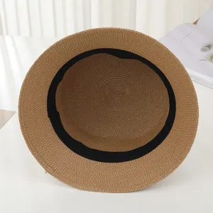 Detail view of a stylish summer straw sun hat in brown with black inner band for women.
