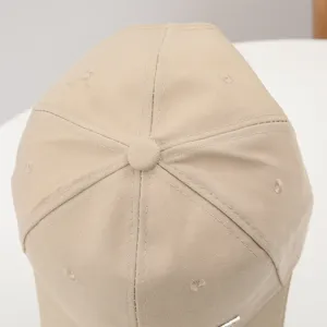 Close-up detail of beige casual baseball cap crown, breathable eyelets and neat stitching.