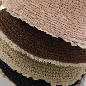 Close-up detail shot of women summer woven straw bucket hat with sweet white lace trim.