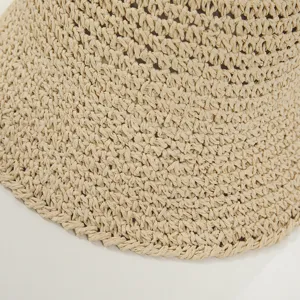 Primo piano dettagliato del cappello secchiello in paglia estiva con trama traforata.