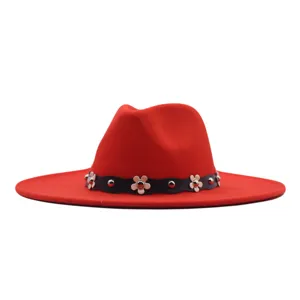 Roter Wollfilz Fedora Hut mit schwarzem wellenförmigem Band und weißen Blumen Metalldetails.