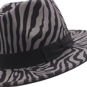 Detail view of zebra print fedora hat with black ribbon band, stylish wool felt hat closeup.