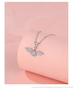 Close-up details of the sterling silver angel wings necklace with sparkling zirconia stones.