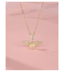 Close-up of a delicate sterling silver angel wing necklace with sparkling zircon and stone.