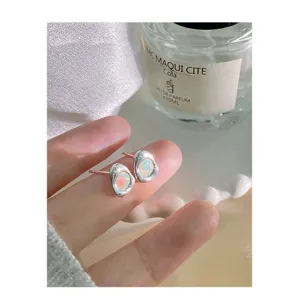 Primer plano detallado de pendientes irregulares de plata de ley con ópalos coloridos.