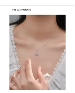 Silver clover pendant necklace detail, elegant clavicle chain closeup, shiny zircon.