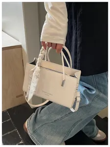Detailed close-up view of elegant women's shoulder handbag with stylish twilly scarf.