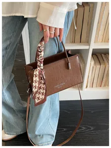 Detailed shot of brown croc pattern crossbody bag with chic scarf handle for women stylish everyday use.