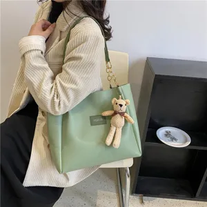 Stylish green shoulder tote bag for women, featuring a cute knit bear pendant and casual daily design.