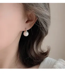 Nahaufnahme Detailaufnahme von eleganten einfachen runden weißen Perlen Silber Ohrringen.