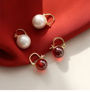 Detailaufnahme von Vintage Perlen und roten Stein Creolen mit elegantem goldenem Finish.