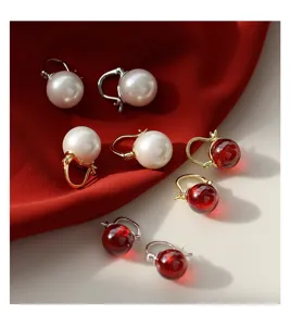 Detailansicht exquisiter Perlen und roter Edelsteinohringe mit silbernen und goldenen.