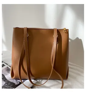Brown PU leather tote bag close-up showing fine texture, durable straps and golden zipper detail.