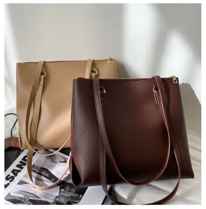 Large capacity brown and khaki leather tote bags detail shot, minimalist design.