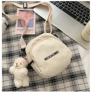 Ins style casual canvas crossbody bag for women, cute white bear pendant, stylish shoulder bag.