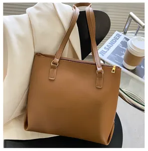 Brown leather tote bag detail shot, featuring large capacity and stylish design in scene setting.