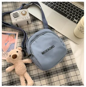 Detailed view of casual blue canvas crossbody bag with letter print, cute design and strap.