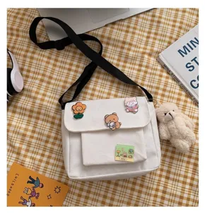 Cute Japanese Harajuku white canvas crossbody bag with cute badges and plush bear pendant.