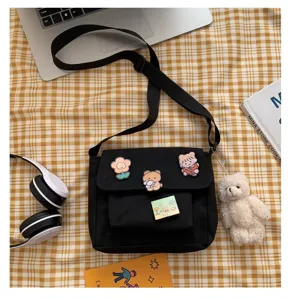 Black canvas crossbody bag for women, cute Japanese style messenger bag with pins and bear charm.