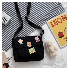 Japanese harajuku style black canvas crossbody bag with cute pins and teddy bear pendant.