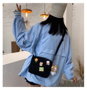 Cute Japanese Harajuku canvas crossbody bag with plush charm for daily student use.