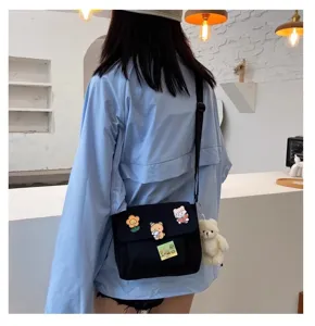 Japanese Harajuku canvas crossbody bag with cute bear pendant and pins for daily student wear.