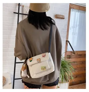 White canvas crossbody bag for women, cute Japanese style student shoulder bag with pins and plush.