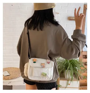 Casual white canvas shoulder bag for women, cute daily crossbody bag with cartoon decor.