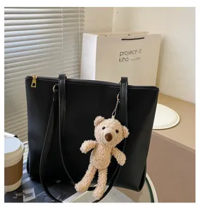 Minimalist black PU leather tote bag with cute plush bear pendant, large capacity design.