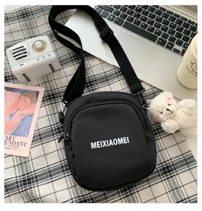 Details of black canvas crossbody bag with letter print, trendy student shoulder bag.