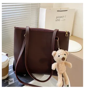 Large capacity brown shoulder tote bag for women with cute plush bear pendant and zipper.