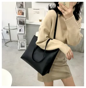 Detail shot of a sleek black PU leather tote bag in a modern lifestyle setting, perfect style.