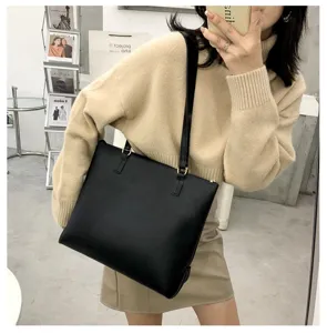 Detailed view of the black leather shoulder tote bag, daily casual wear style in mirror selfie.