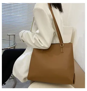 Detailed shot of a stylish brown leather tote shoulder bag, showcasing large capacity and elegant design.