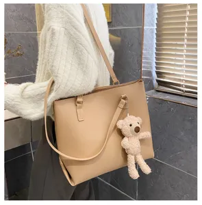 Details of the women's large capacity PU leather shoulder tote bag with cute bear charm.