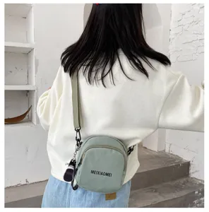 Green canvas crossbody bag for women, stylish small shoulder bag with adjustable strap.