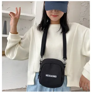 Detailed shot of a casual black canvas crossbody bag worn by a model, perfect for daily use.