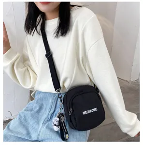 Detailed view of fashionable black canvas crossbody bag for women, cute student shoulder bag.