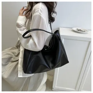 Vue détaillée du sac cabas souple en cuir porté par le mannequin, élégant et décontracté.