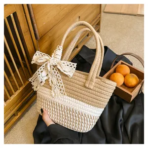 Detailed view of the woven tote bag featuring chic color block design and elegant lace bow.