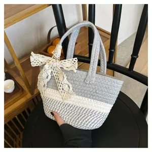 Detailed shot of a woven color block tote bag featuring an elegant lace bow and dual handles.