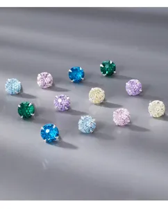 Detail de boucles d'oreilles clous en zircon colore et argent, bijou minimaliste quotidien.