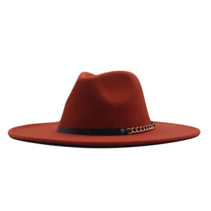Nahaufnahme des breitkrempigen Fedora-Hutes mit schwarzem Lederriemen und goldenen Kettendetails.