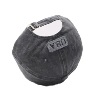 Washed distressed cotton baseball cap detail view, adjustable metal buckle and USA embroidery patch.