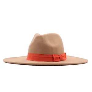 Nahaufnahme des beigen Fedora-Hutes mit breiter Krempe und leuchtend orangener Schleife.